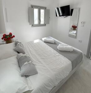 a large white bed with two pillows on it at Fira Heart Studios in Fira +6 photos