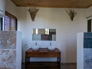 ein Badezimmer mit zwei Waschbecken und einem Spiegel in der Unterkunft Villa Natura in Ambondrona + 12 Fotos
