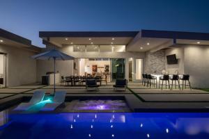 a house with a swimming pool in front of a house at Neon @ Elemento49 Pool Spa Sleeps 16 in Desert Groves Mobile Home Park