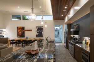 a kitchen with a counter top and a dining room at Neon @ Elemento49 Pool Spa Sleeps 16 in Desert Groves Mobile Home Park