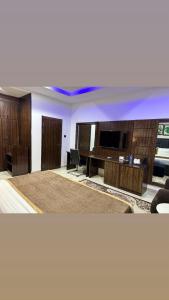 Una sala de estar con un escritorio y un televisor. en Vinpy hotels, en Uyo