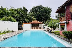 a swimming pool in front of a house at Casa Komala Uluwatu in Uluwatu