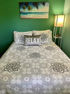 Royal Palm Cottage Hawaii في Hakalau: غرفة نوم بها سرير عليه لافتة "استرخاء" +24 صورة