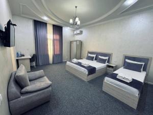 タシュケントにあるArt Tashkentのベッド2台と椅子があるホテルの部屋 +20枚の写真