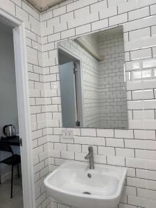 un bagno bianco con lavandino e specchio di The9motel a Ngao