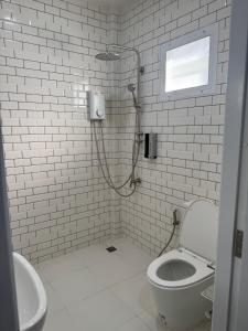 un bagno con doccia, wc e lavandino di The9motel a Ngao