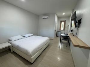 una camera da letto bianca con un letto e una scrivania di The9motel a Ngao Altre 2 foto