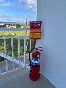 un idrante antincendio accanto a un cartello su un balcone di The9motel a Ngao