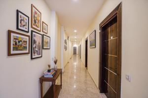 a hallway with paintings on the walls and a hallway with a door at Via Red Diamond in Ghaziabad