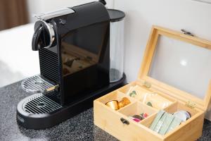 a black coffee maker sitting on a table with a wooden box at STAYY Nº7 Suites & Studios -Self Check-in in Zürich
