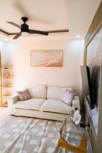 a living room with a white couch and a flat screen tv at Summer Bay Luxury Suite - West End - Roatán in Coxen Hole
