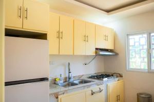 a kitchen with white cabinets and a sink at Summer Bay Luxury Suite - West End - Roatán in Coxen Hole +5 photos