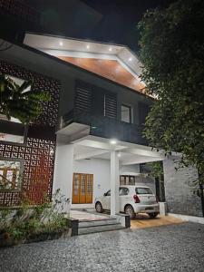 een witte auto geparkeerd voor een huis bij Aathira Agri Homes in Trichūr