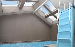 8 Bedroom Lovely Home In Vejers Strand في فايرس ستراند: غرفة علوية مزودة بسلم ونافذة سقفية