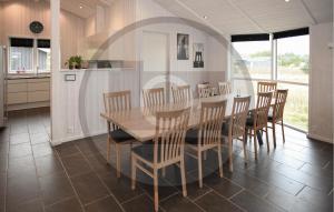 8 Bedroom Lovely Home In Vejers Strand في فايرس ستراند: غرفة طعام مع طاولة وكراسي خشبية
