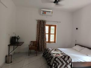 een slaapkamer met een bed en een raam bij Aathira Agri Homes in Trichūr