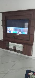 een flatscreen-tv zittend op een stand bij Aathira Agri Homes in Trichūr