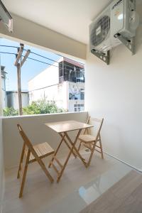 a table and chairs in a room with a window at The Nook Hotel in Chiang Mai