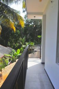 a balcony of a house with a fence and trees at Sunny's Hide Out in Talalla