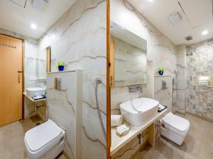 Un baño con dos inodoros, un lavabo y un espejo. en Hotel New King Castle International- Free Airport Pick up, en Nueva Delhi