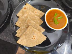 a plate with tortilla chips and a bowl of soup at Ravi's beach villa in Alleppey