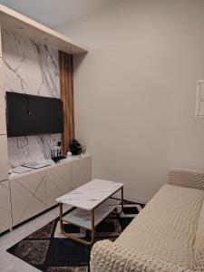 a bedroom with a bed and a table and a tv at three x apartelle in Tagbilaran City