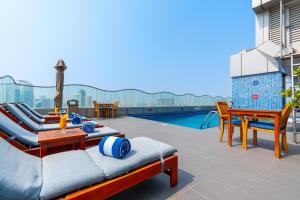 Un patio con mesa y sillas y una piscina. en Samaya Hotel Deira, en Dubái