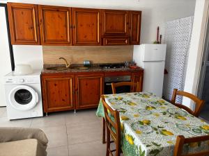 a kitchen with a table and a stove and a refrigerator at Red House in Montecorvino Rovella