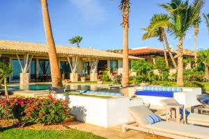 a villa with a swimming pool and palm trees at Casa Piedra Blanca in San José del Cabo