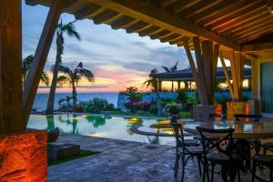 a resort patio with a pool and a table and chairs at Casa Piedra Blanca in San José del Cabo