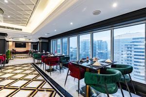 Un restaurante con mesas y sillas y grandes ventanales. en Samaya Hotel Deira, en Dubái