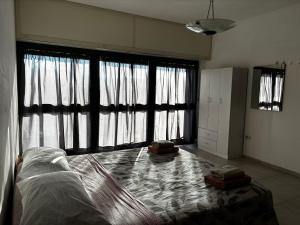 a bedroom with a bed and large windows at Red House- Camera per quattro in Montecorvino Rovella