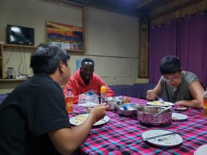 a group of men sitting at a table eating food at Nanja Mara Lodge in Masai Mara