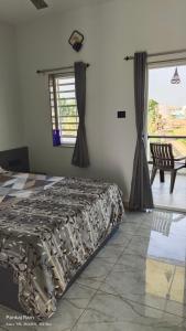 a bedroom with a bed and a large window at Shree Krushn in Bhuj