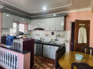 una cocina con una mesa y una encimera en Below The Hills suite WHome Theatre, en Katmandú