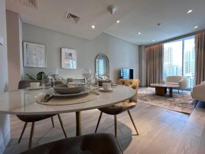 a dining room with a table and chairs and a living room at Casa Royale Vacation Home - Dubai Marina in Dubai