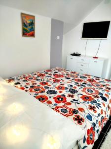 a bedroom with a bed with a floweridered comforter at Tara Mountain House in Bajina Bašta +18 photos