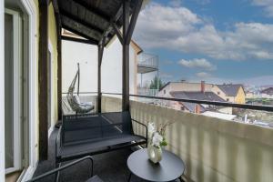a balcony with a table and a chair on a balcony at COY Apartments Leoben - Stay Comfortable & Work Smart in Leoben