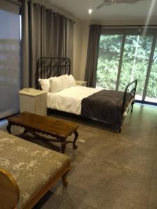 een slaapkamer met 2 bedden, een bank en een raam bij Reef House in Ballito