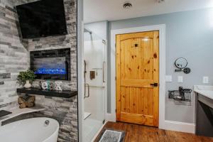 a bathroom with a white tub and a wooden door at Fishersville Oasis in Fishersville
