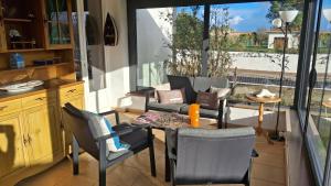 ein Esszimmer mit Stühlen, einem Tisch und einem Fenster in der Unterkunft Maison de vacances 6 personnes in Saint-Hilaire-de-Riez