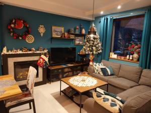 a living room with a christmas tree on the wall at Villa Eva & Lilou Pod Rysianką in Żabnica
