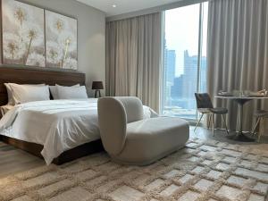 a bedroom with a bed and a chair and a table at Casa Royale Vacation Home - Dubai Marina in Dubai +211 photos