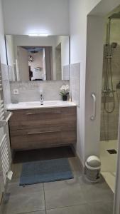 ein Bad mit einer Badewanne und einer Dusche mit einem Spiegel in der Unterkunft Maison de vacances 6 personnes in Saint-Hilaire-de-Riez