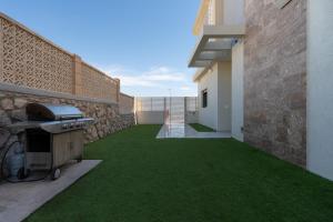 a backyard with a grill and green grass at Dreamy Rent- Aqua Vista eilat in Eilat