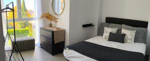 ein Schlafzimmer mit einem Bett, einem Spiegel und einem Fenster in der Unterkunft POWER HOME in Granada
