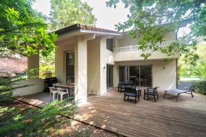a patio with chairs and tables in front of a house at Villa HOUX & IVY 3 chambres proche Lac Marin rive est -Wifi #0384 in Hossegor