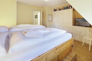 two twin beds in a room with a tv at Perle am Watt in List