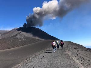 a group of people walking down a dirt road with a volcano at Garibaldi guest house in Catania +5 photos