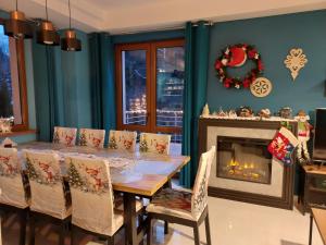 a dining room with a table and a fireplace at Villa Eva & Lilou Pod Rysianką in Żabnica